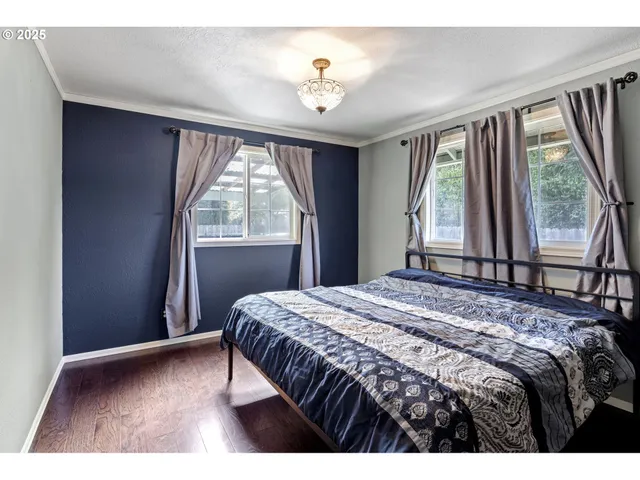 a bedroom with a bed and a large mirror on the dresser