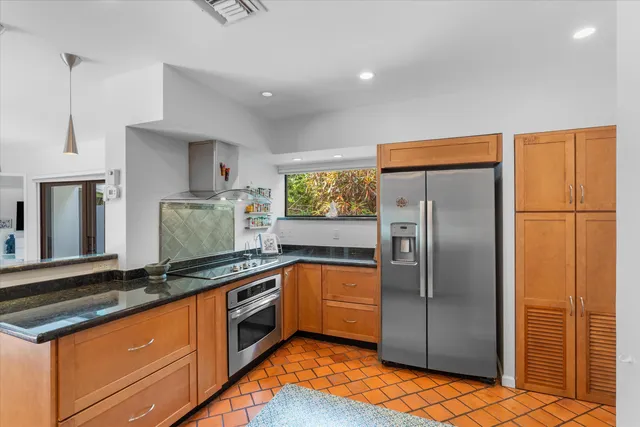 a kitchen with stainless steel appliances granite countertop a stove a sink and a refrigerator