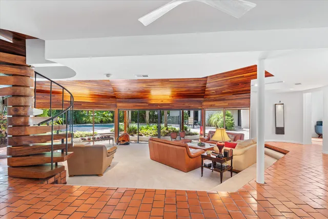 a living room with patio furniture and a potted plants