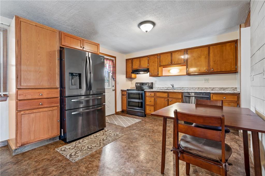 1885 George Circle Irwin, PA 15642 - Photo 9 of 25 a kitchen with stainless steel appliances granite countertop a refrigerator a stove and a sink