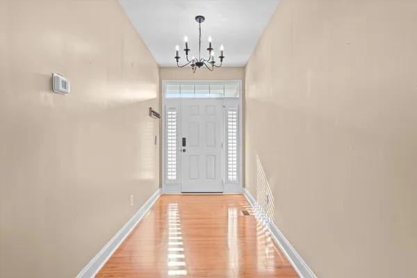 a view of a livingroom with wooden floor and a chandelier