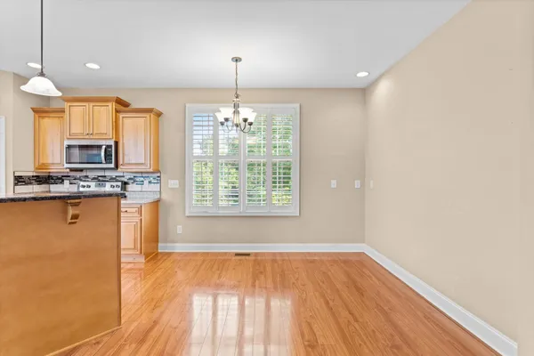 a view of kitchen with granite countertop cabinets and wooden floor