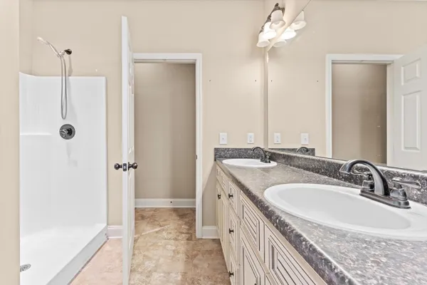 a bathroom with a double vanity sink a mirror and a bathtub