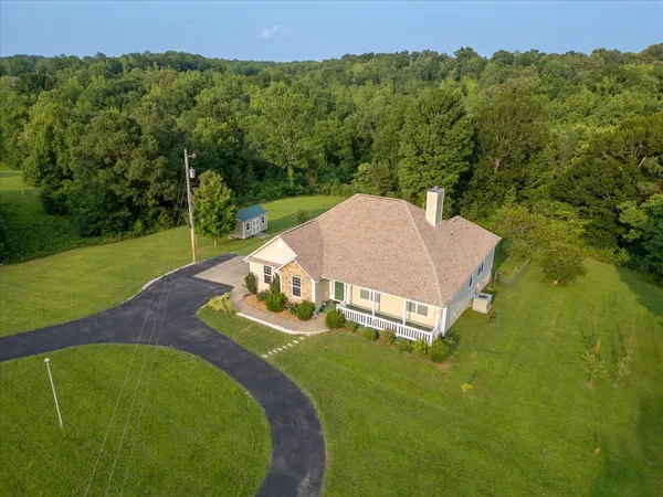 a view of a house with pool and a yard