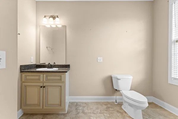 a bathroom with a toilet a sink and mirror