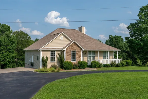 a front view of a house with a yard and potted plants