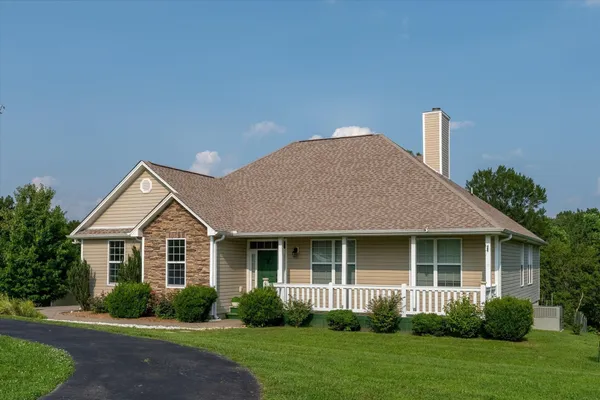 a front view of a house with a yard and green space
