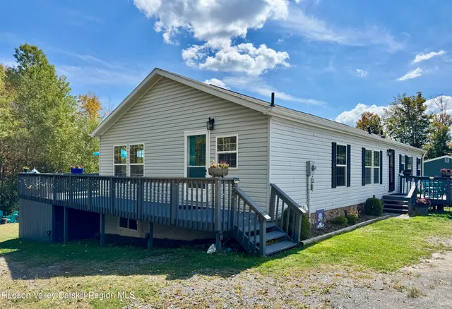 a view of a house with a yard and deck