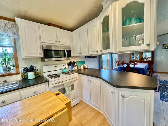 a kitchen with stainless steel appliances granite countertop a sink a stove and a microwave