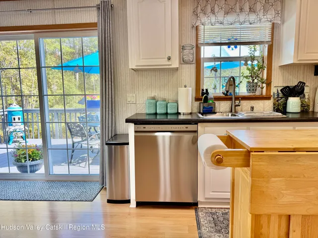 a kitchen with a refrigerator a stove a sink and a dining table with chairs