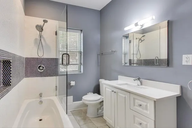 a bathroom with a bathtub sink mirror and toilet