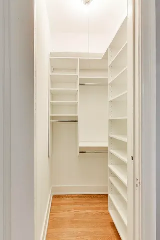 a view of walk in closet with empty racks