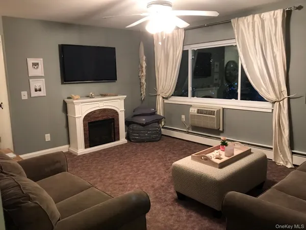 a living room with furniture a flat screen tv and a fireplace