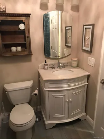 a bathroom with a toilet sink and mirror