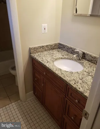 a bathroom with a granite countertop sink and a mirror