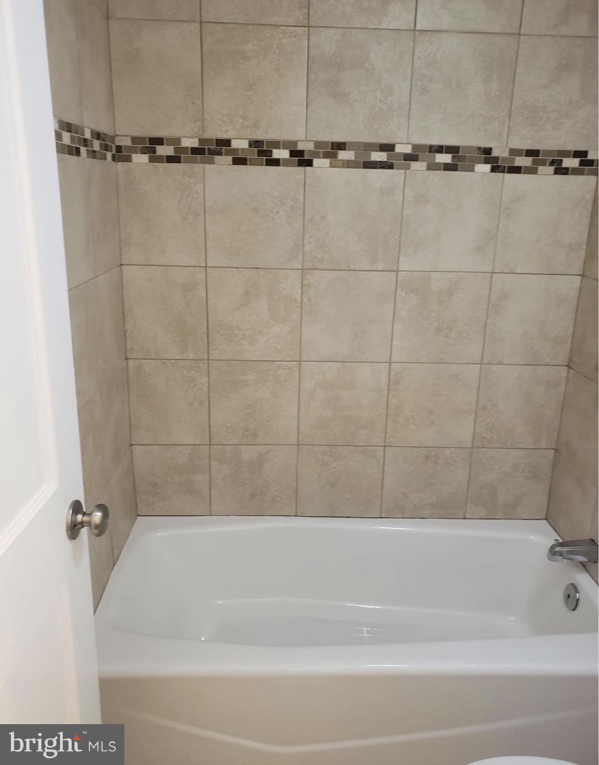 4102 Queensbury Road Hyattsville, MD 20781 - Photo 3 of 6 a bathroom with a shower and a bathtub