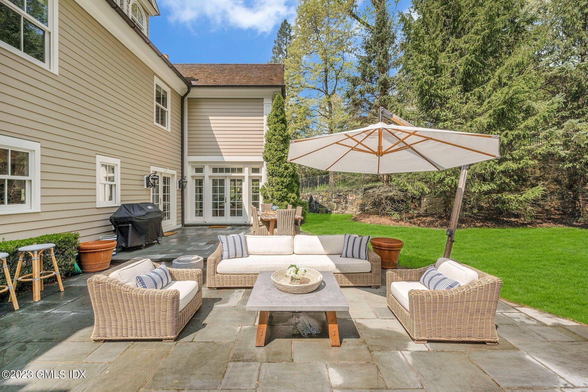 53 Hillside Road Greenwich, CT 06830 - Photo 29 of 37 a view of a patio with couches chairs and a umbrella