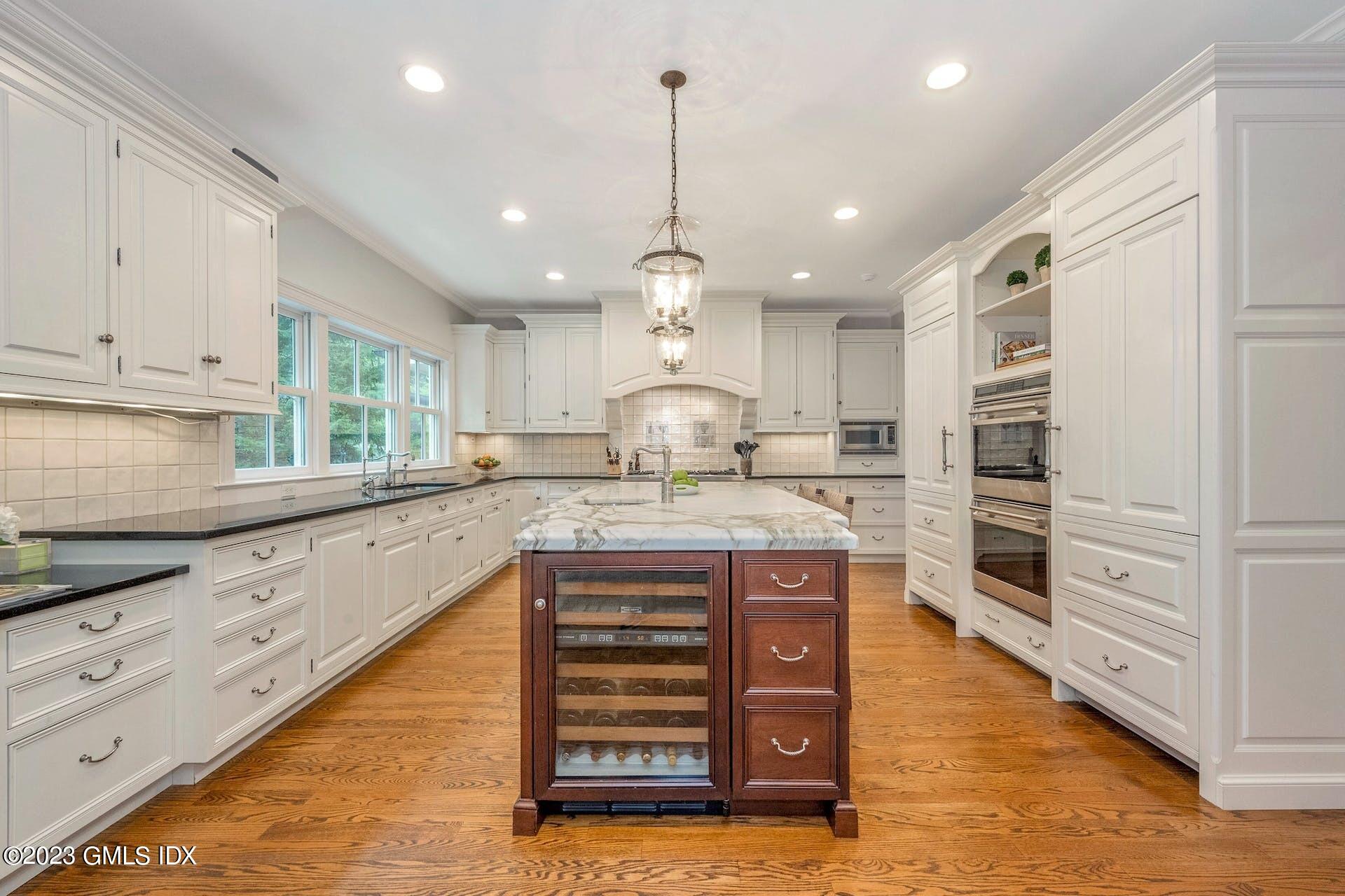 53 Hillside Road Greenwich, CT 06830 - Photo 7 of 37 a kitchen with kitchen island granite countertop a stove oven and a sink with cabinets