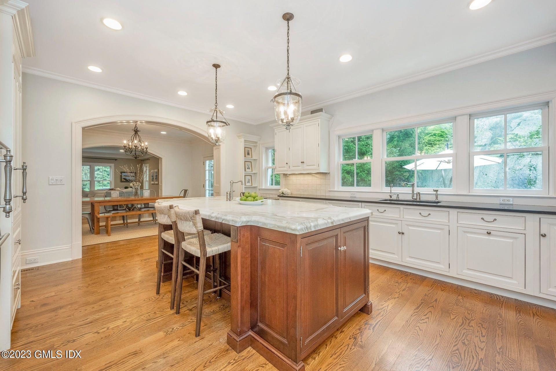53 Hillside Road Greenwich, CT 06830 - Photo 8 of 37 a kitchen with granite countertop a stove a sink a dining table and chairs with wooden floor