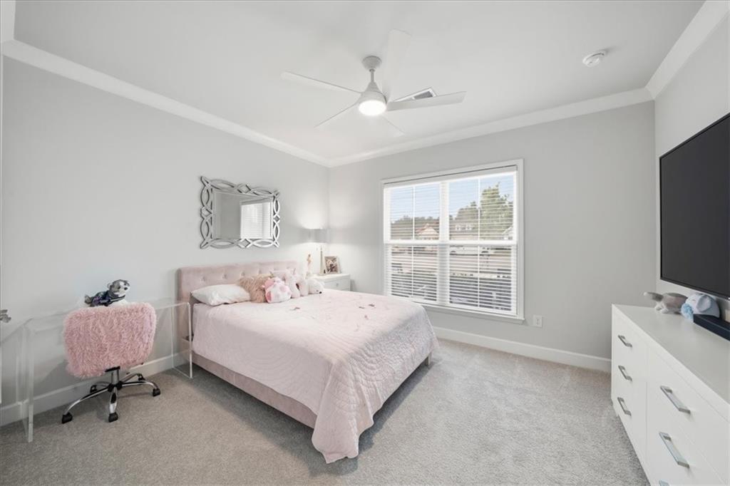2457 Naples Street Hoschton, GA 30548 - Photo 22 of 41 a spacious bedroom with a bed and a flat screen tv