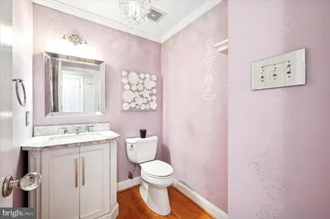 a bathroom with a toilet sink vanity and mirror