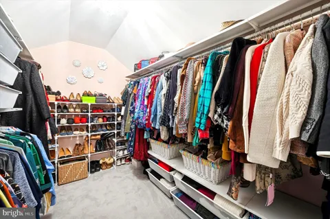 a view of walk in closet with clothes and shoes