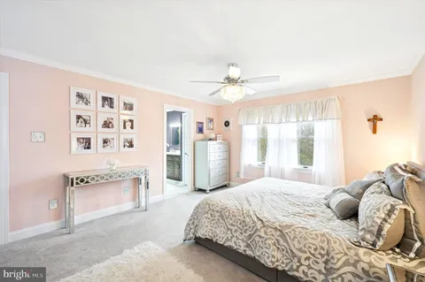 a bedroom with a large bed a chandelier and a window