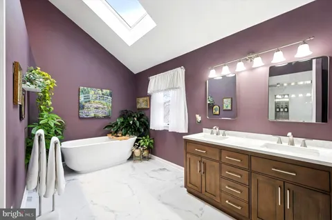 a spacious bathroom with a double vanity sink a large mirror and a bathtub