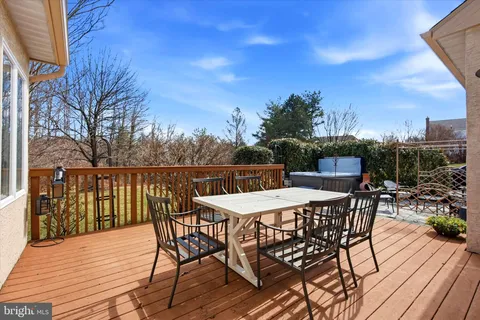 a view of a roof deck with table and chairs a barbeque with wooden floor and fence