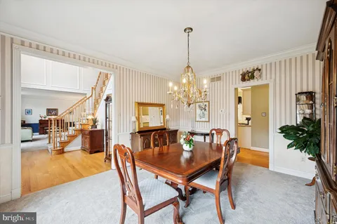 a dining room with furniture a chandelier and wooden floor