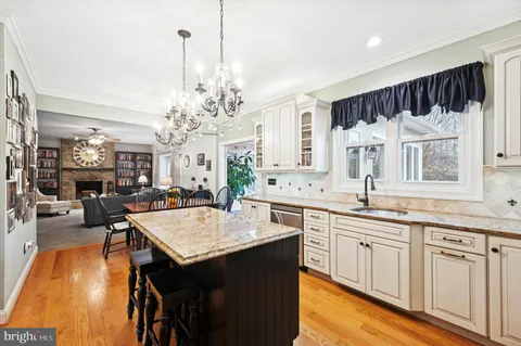 a large kitchen with kitchen island granite countertop a sink cabinets and wooden floor