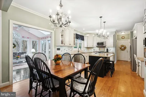 a view of a dining room with furniture a chandelier and wooden floor