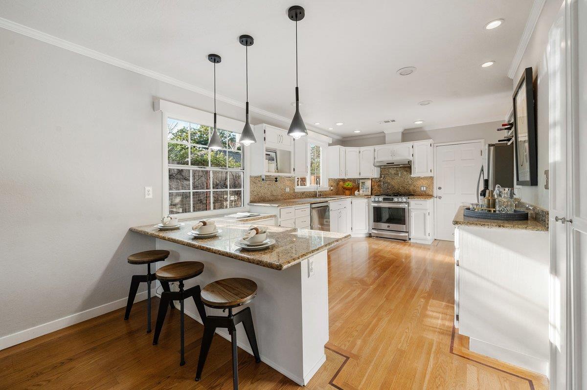 1277 Edgewood Road Redwood City, CA 94062 - Photo 23 of 49 a kitchen with stainless steel appliances granite countertop a stove and a wooden floors