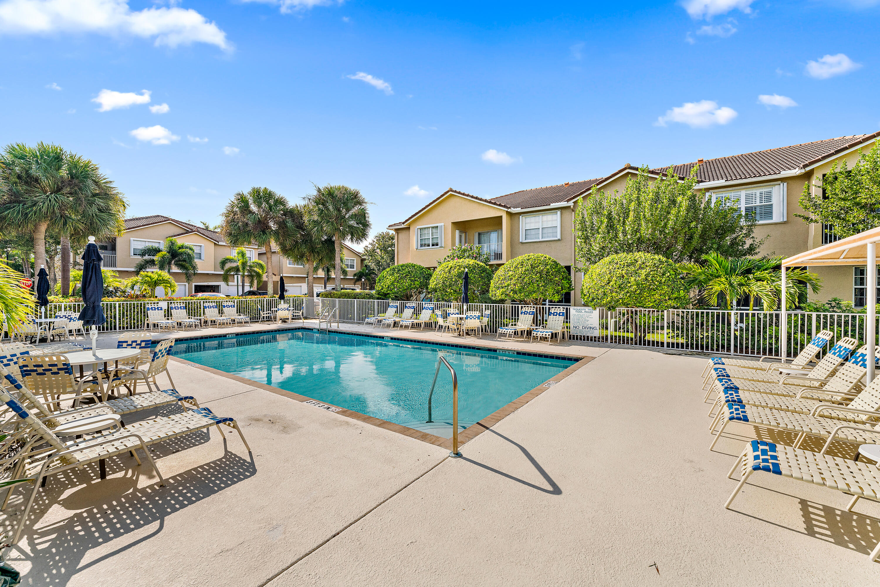 106 Lighthouse Circle, Unit G Tequesta, FL 33469 - Photo 1 of 35 a view of a swimming pool with a lounge chairs