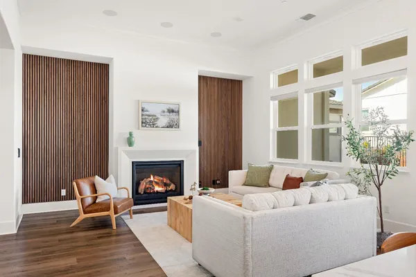 a living room with furniture a fireplace and a large window