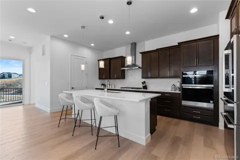 a kitchen with stainless steel appliances granite countertop wooden cabinets a refrigerator and sink