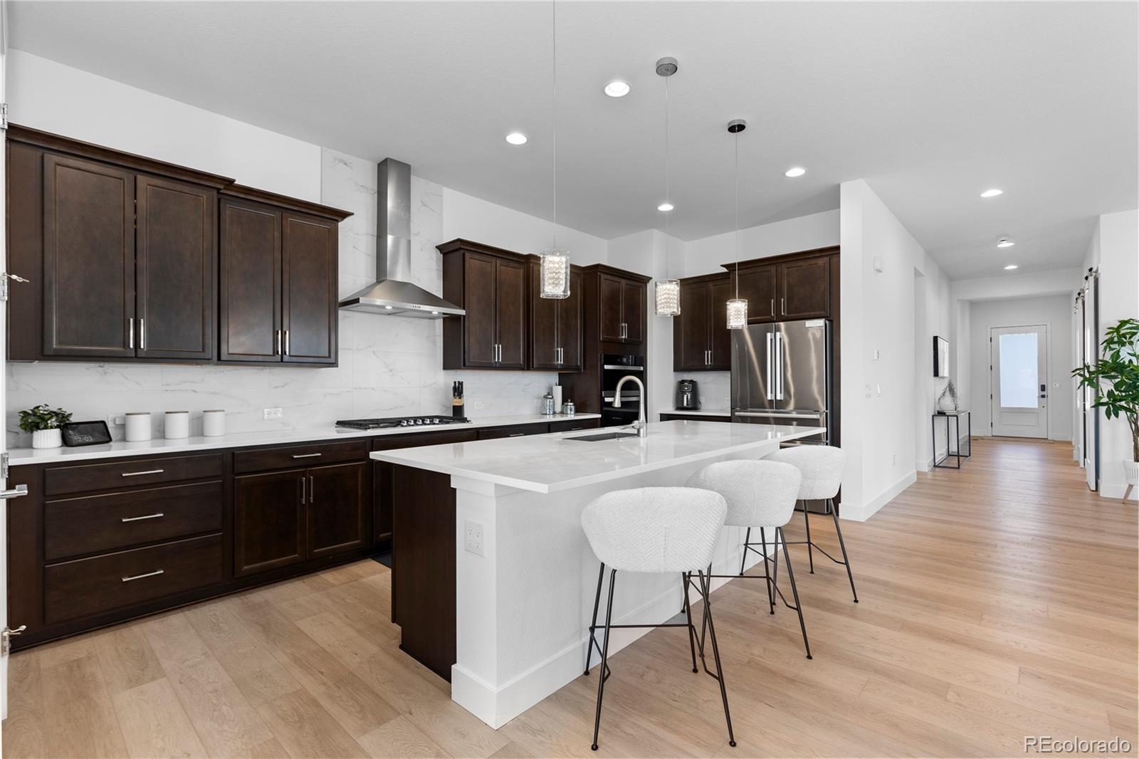6610 Fawn Path Lane Castle Pines, CO 80108 - Photo 17 of 50 a kitchen with stainless steel appliances granite countertop wooden cabinets a refrigerator and sink