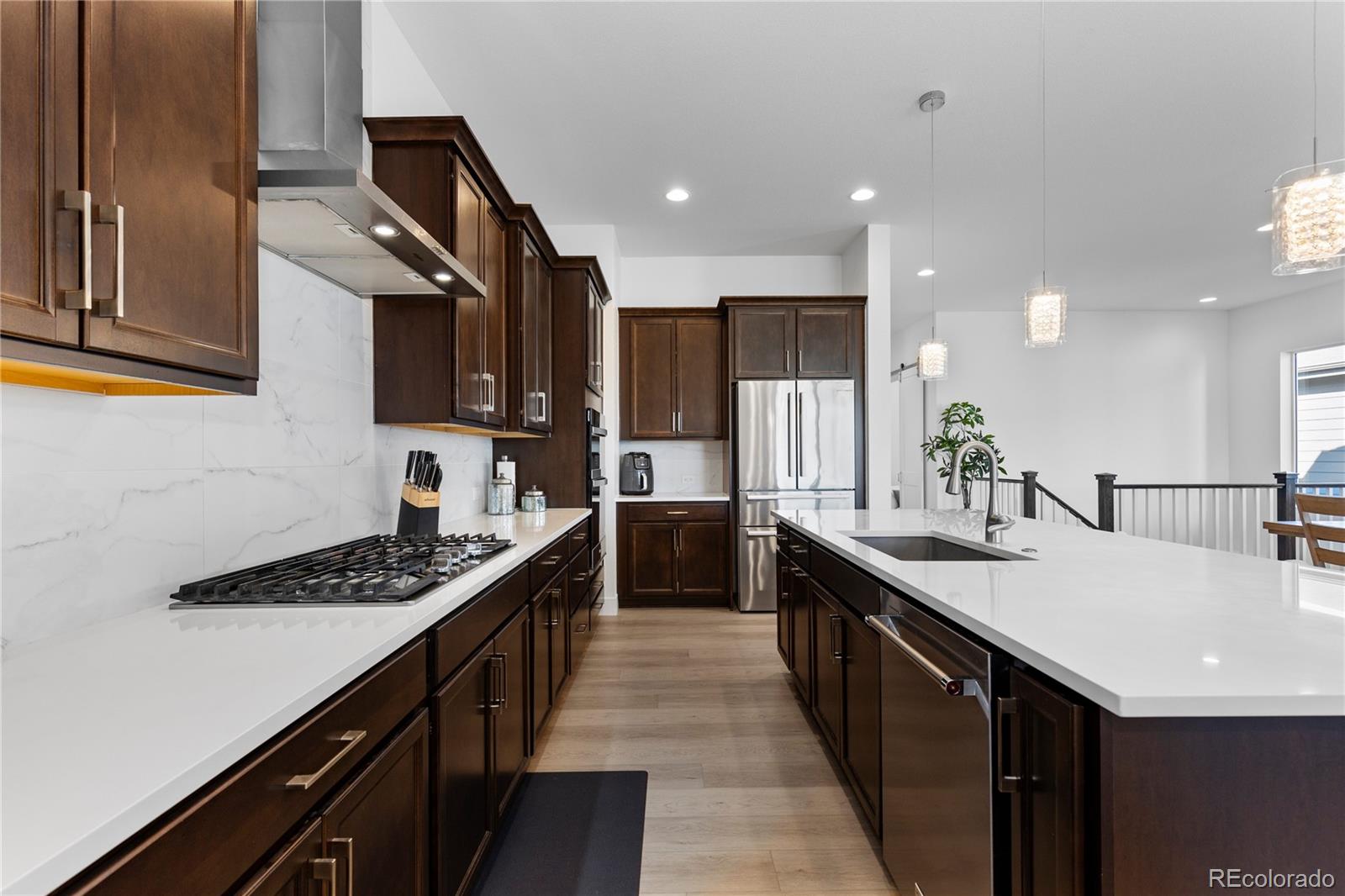 6610 Fawn Path Lane Castle Pines, CO 80108 - Photo 18 of 50 a kitchen with stainless steel appliances kitchen island granite countertop a sink a stove top oven a counter space and cabinets
