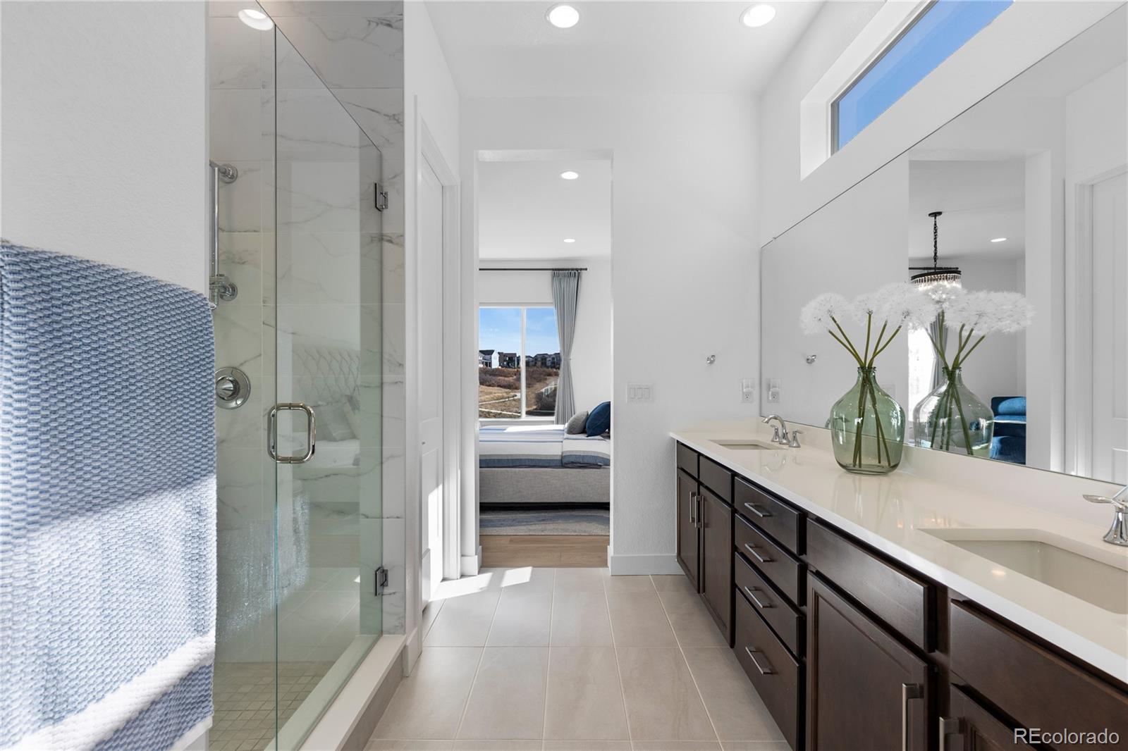 6610 Fawn Path Lane Castle Pines, CO 80108 - Photo 31 of 50 a en suite bathroom with a granite countertop sink mirror and shower