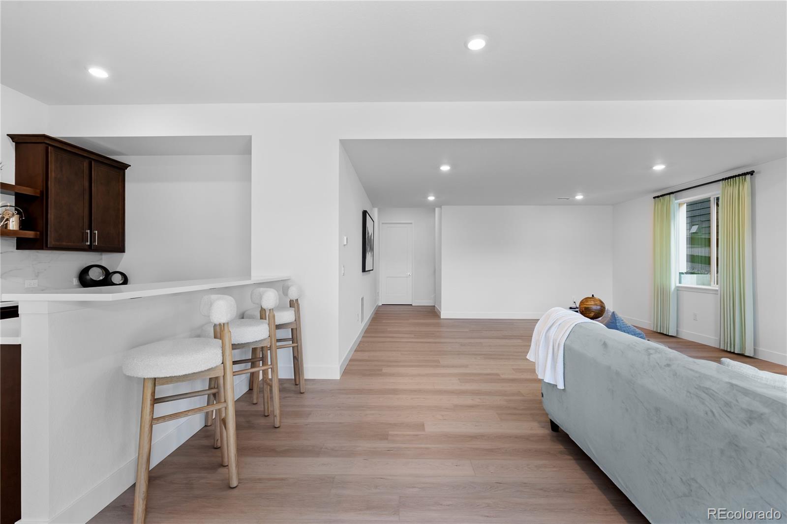 6610 Fawn Path Lane Castle Pines, CO 80108 - Photo 37 of 50 a hallway with a couch and a flat screen tv