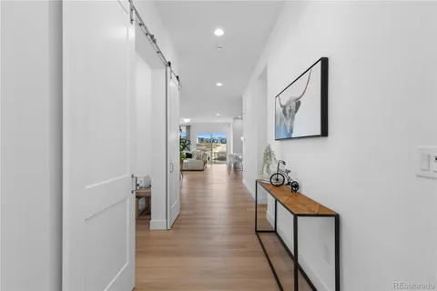 a hallway with wooden floor a sink and a stove with wooden floor