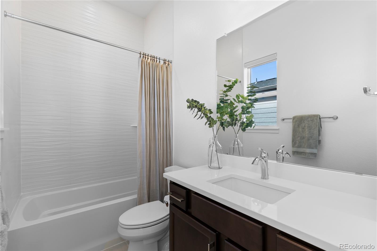 6610 Fawn Path Lane Castle Pines, CO 80108 - Photo 41 of 50 a bathroom with a granite countertop sink toilet a large mirror and shower