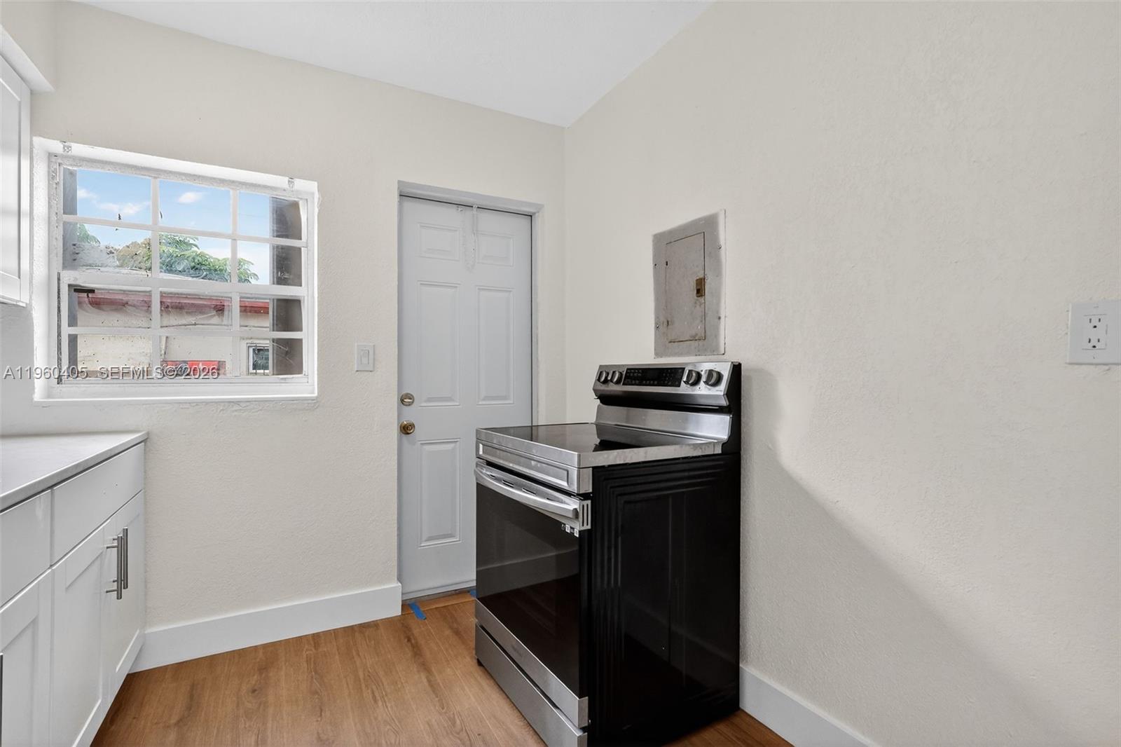 280 Northwest 34th Street Miami, FL 33127 - Photo 12 of 34 a view of an empty room with wooden floor and a window