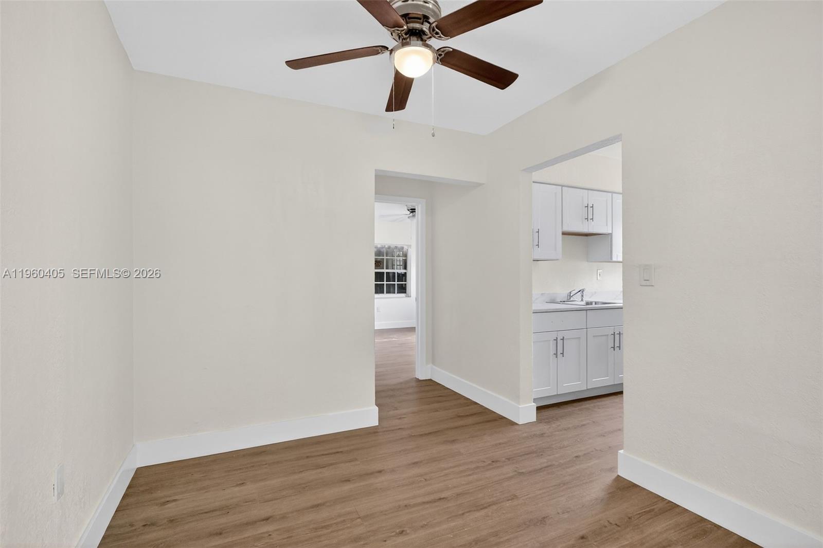 280 Northwest 34th Street Miami, FL 33127 - Photo 8 of 34 a view of a kitchen with wooden floor and a ceiling fan
