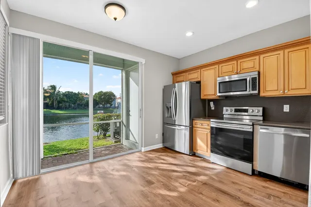 a kitchen with stainless steel appliances granite countertop a refrigerator and a stove top oven