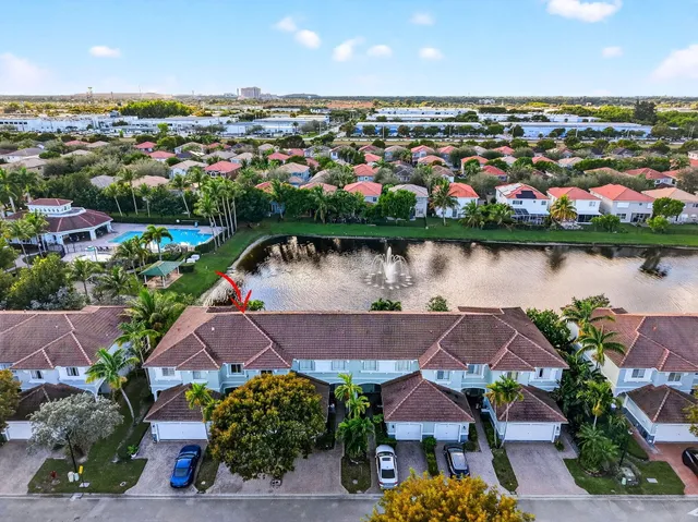 an aerial view of residential houses with outdoor space and lake view