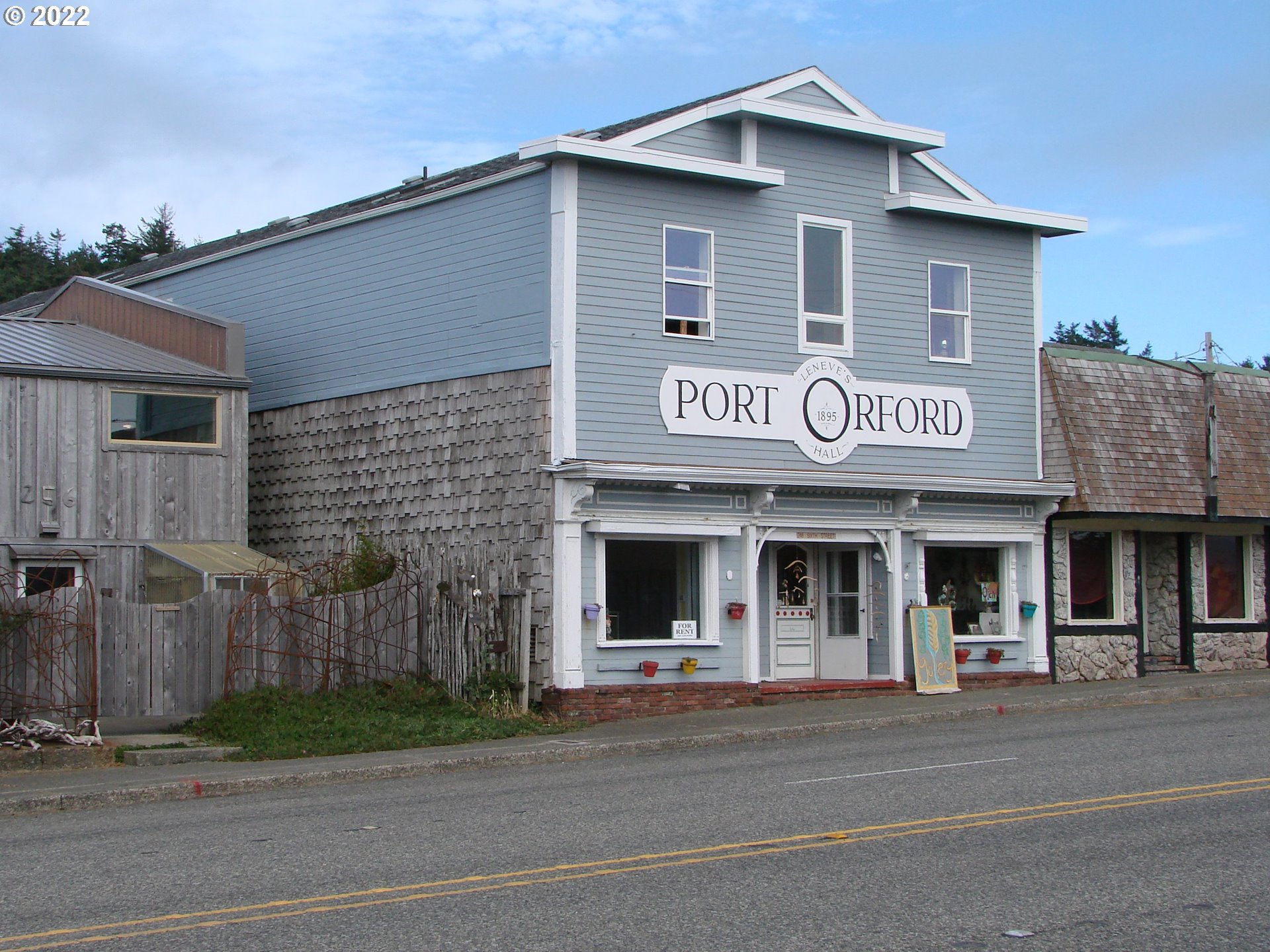 246 6th Street Port Orford, OR 97465 - Photo 2 of 34 a view of a house with a small yard and large parking space