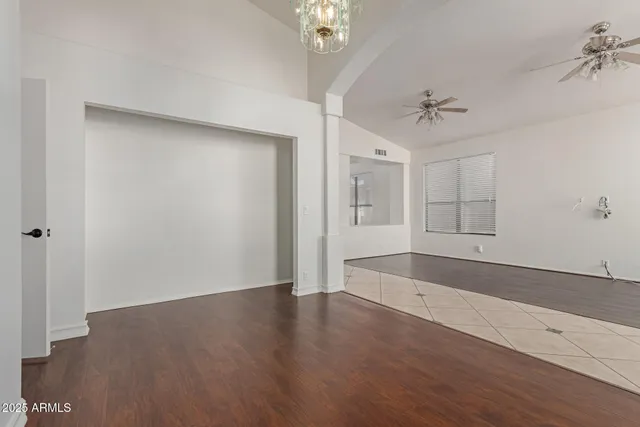 a view of a room with wooden floors and ceiling fan