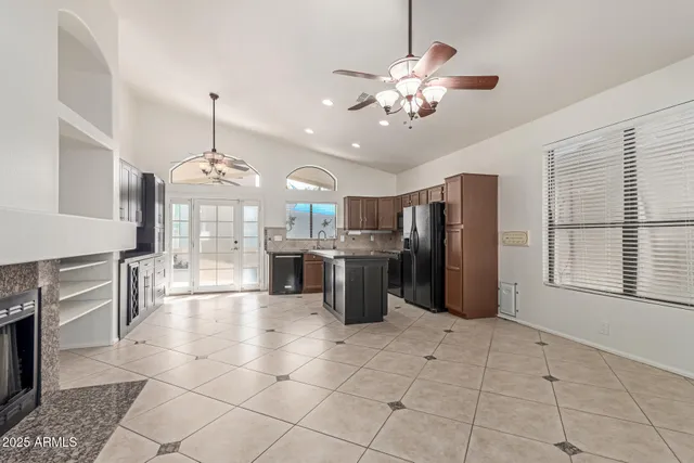 a large kitchen with stainless steel appliances kitchen island granite countertop a refrigerator a stove a sink dishwasher with a dining table and chairs