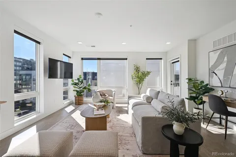a living room with furniture potted plant and a flat screen tv